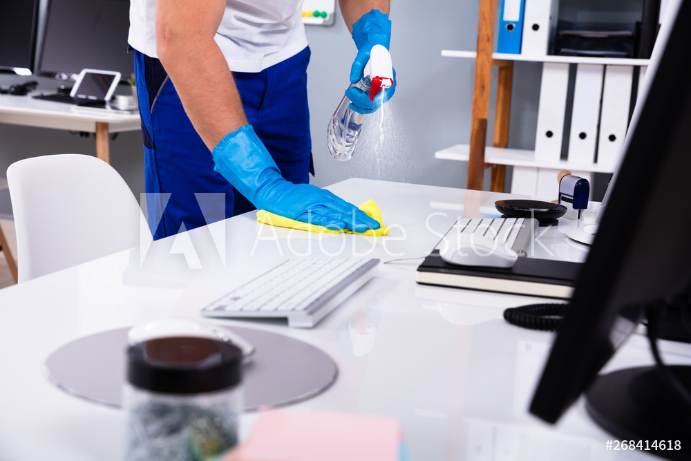 Professional office cleaning team sanitizing workspaces